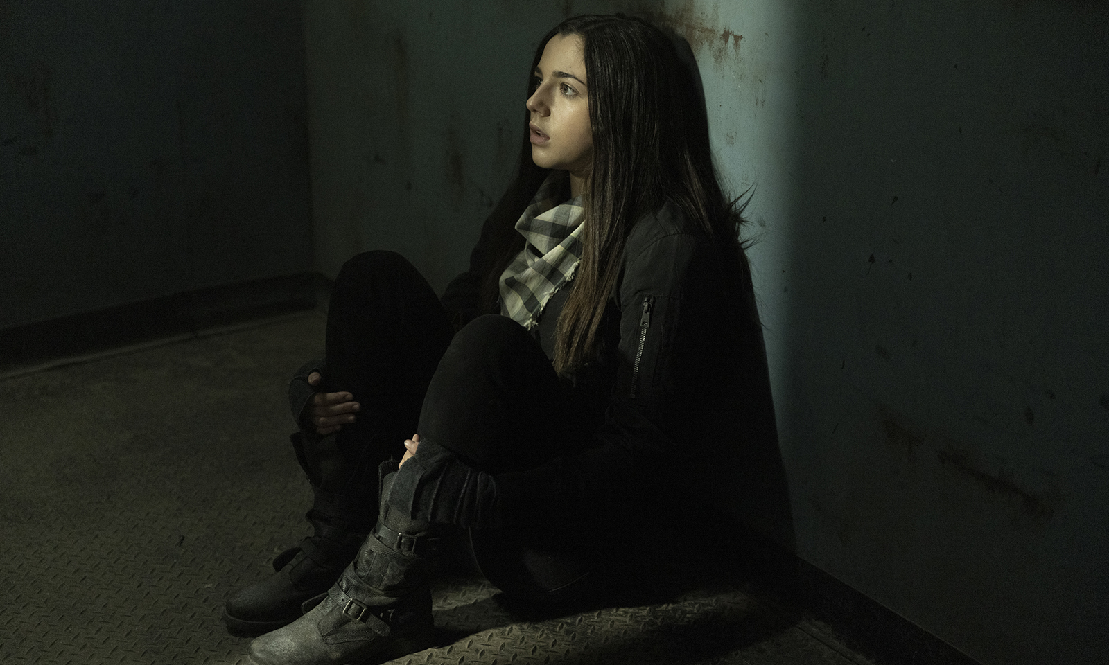 Charlie sentada no chão em cena do episódio 10 da 7ª temporada de Fear the Walking Dead.