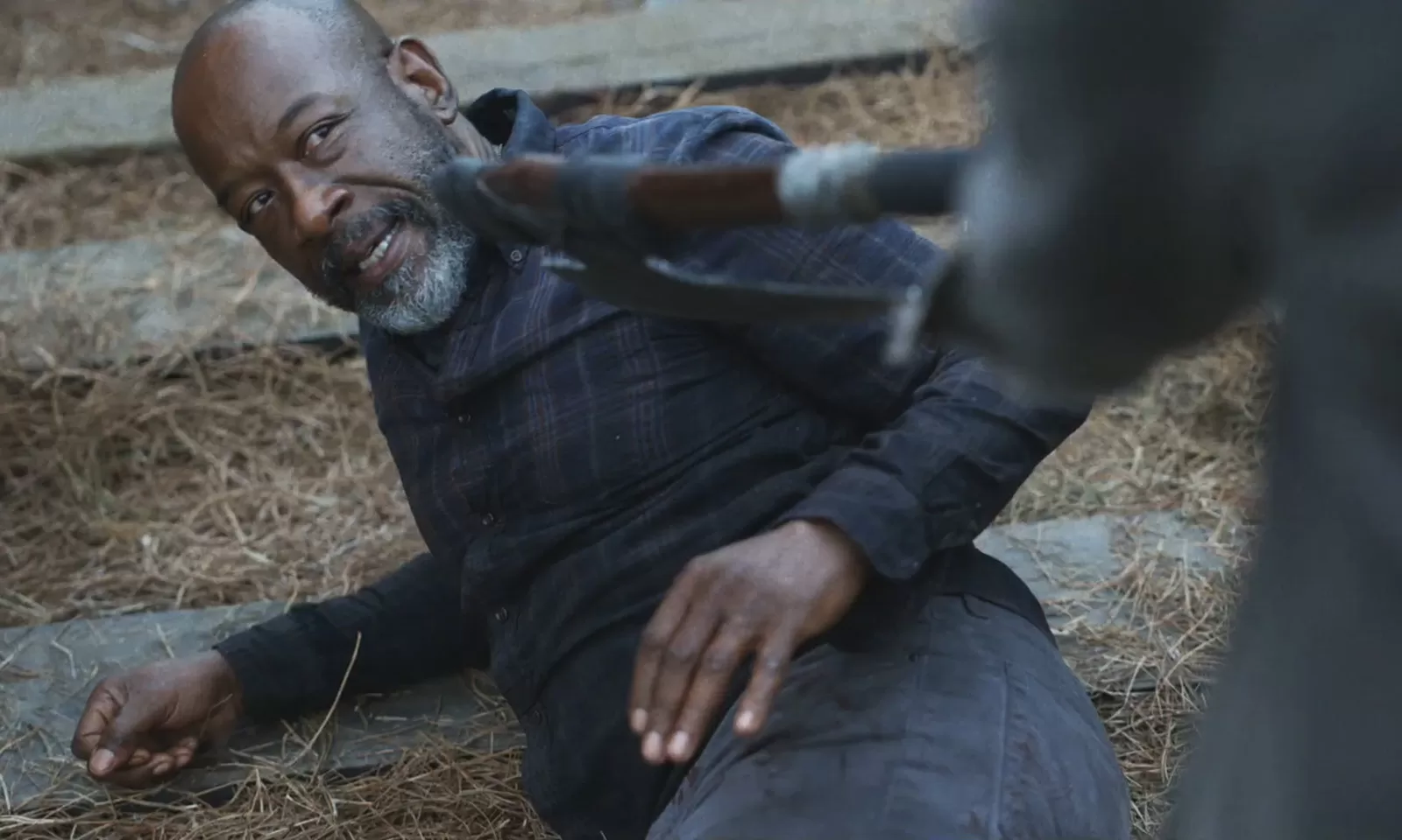 Morgan no chão com sua arma sendo apontada para ele em cena da 8ª temporada de Fear the Walking Dead.